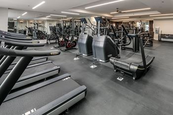 a gym with cardio equipment and weights on the floor at The Grand Central, Chicago